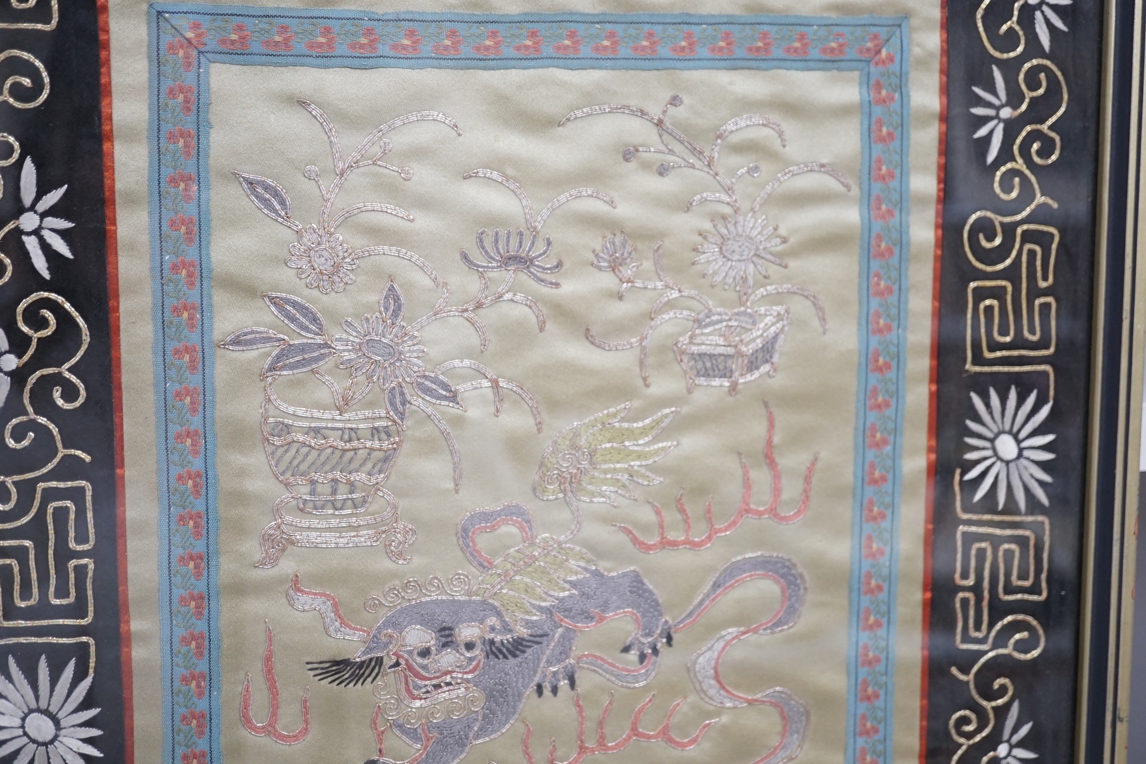 A framed Chinese dragon silk panel. 64 x 34cm